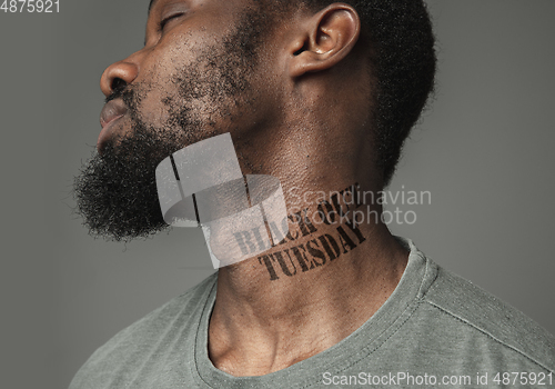 Image of Close up portrait of a black man tired of racial discrimination has tattooed slogan on his neck