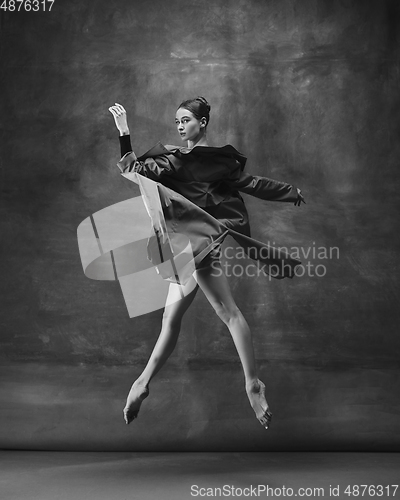 Image of Young graceful tender ballerina on dark studio background