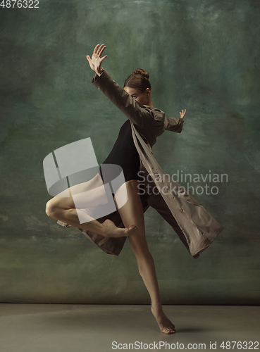 Image of Young graceful tender ballerina on dark studio background