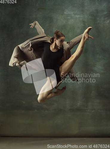 Image of Young graceful tender ballerina on dark studio background