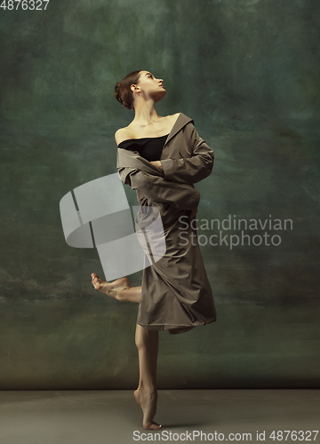 Image of Young graceful tender ballerina on dark studio background