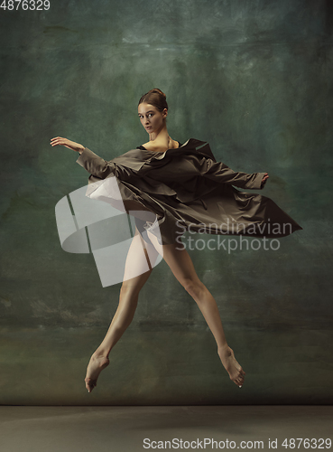 Image of Young graceful tender ballerina on dark studio background