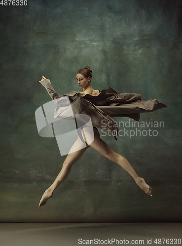 Image of Young graceful tender ballerina on dark studio background