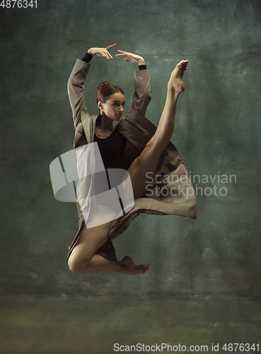 Image of Young graceful tender ballerina on dark studio background