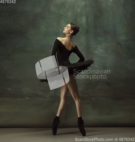 Image of Young graceful tender ballerina on dark studio background