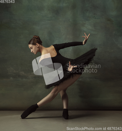 Image of Young graceful tender ballerina on dark studio background