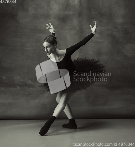 Image of Young graceful tender ballerina on dark studio background