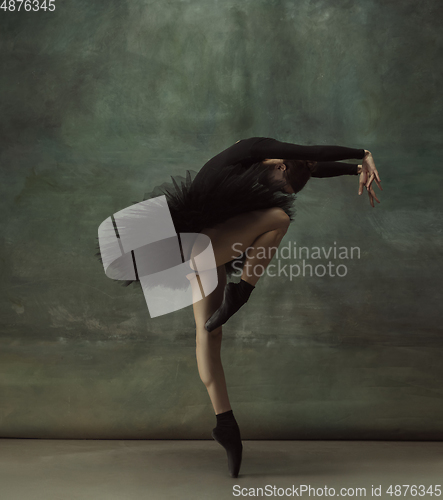 Image of Young graceful tender ballerina on dark studio background