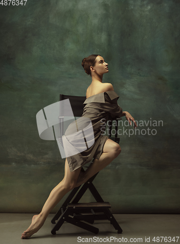 Image of Young graceful tender ballerina on dark studio background