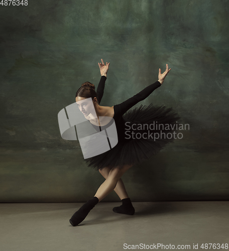 Image of Young graceful tender ballerina on dark studio background