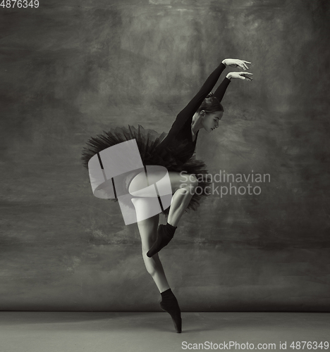 Image of Young graceful tender ballerina on dark studio background