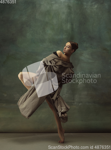 Image of Young graceful tender ballerina on dark studio background