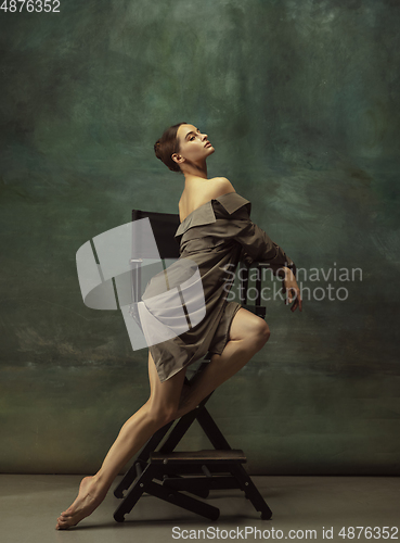 Image of Young graceful tender ballerina on dark studio background