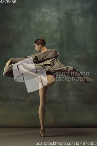 Image of Young graceful tender ballerina on dark studio background