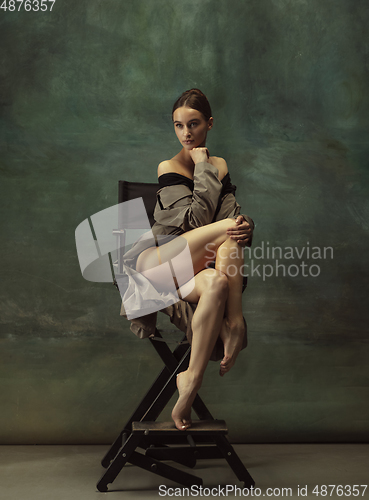 Image of Young graceful tender ballerina on dark studio background