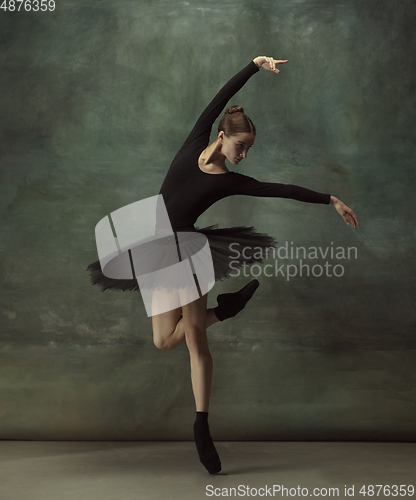 Image of Young graceful tender ballerina on dark studio background