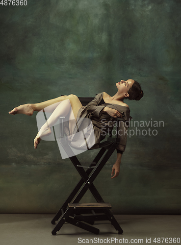 Image of Young graceful tender ballerina on dark studio background