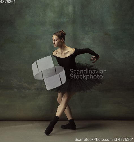 Image of Young graceful tender ballerina on dark studio background