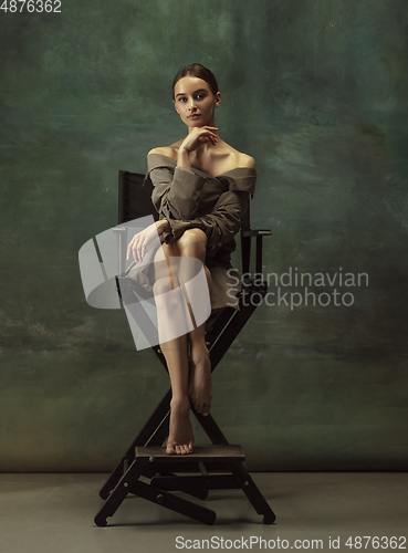 Image of Young graceful tender ballerina on dark studio background