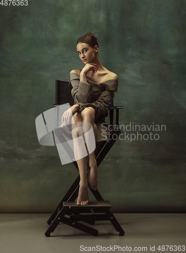 Image of Young graceful tender ballerina on dark studio background