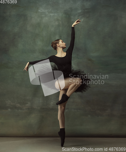 Image of Young graceful tender ballerina on dark studio background