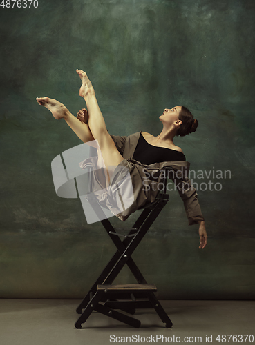 Image of Young graceful tender ballerina on dark studio background