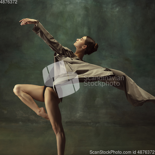 Image of Young graceful tender ballerina on dark studio background