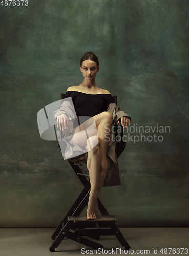 Image of Young graceful tender ballerina on dark studio background