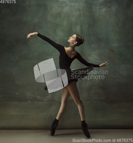 Image of Young graceful tender ballerina on dark studio background