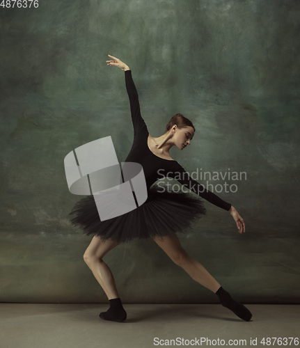 Image of Young graceful tender ballerina on dark studio background