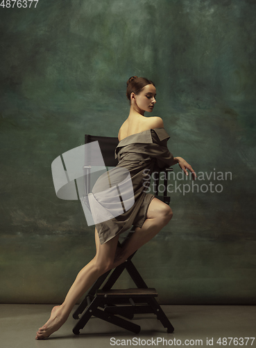 Image of Young graceful tender ballerina on dark studio background