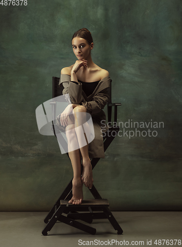 Image of Young graceful tender ballerina on dark studio background