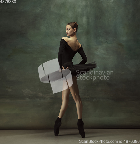 Image of Young graceful tender ballerina on dark studio background