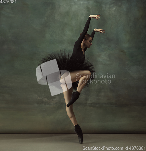 Image of Young graceful tender ballerina on dark studio background