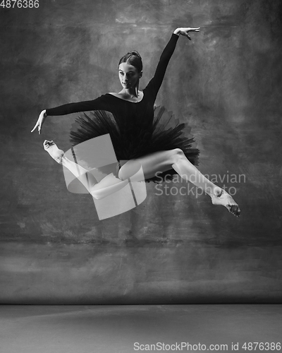 Image of Young graceful tender ballerina on dark studio background