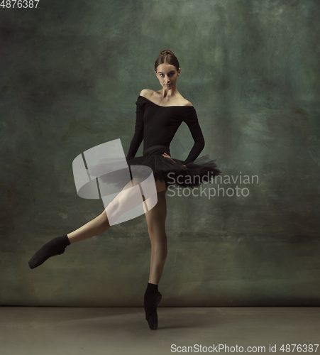 Image of Young graceful tender ballerina on dark studio background