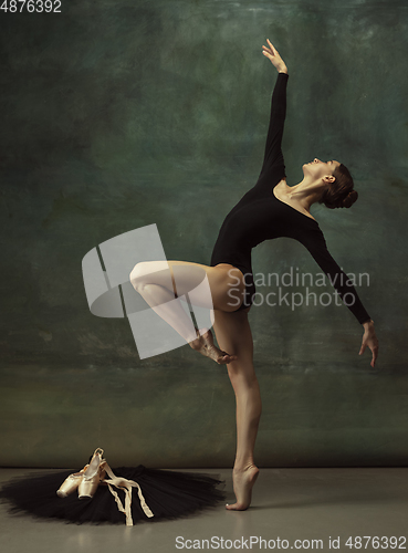 Image of Young graceful tender ballerina on dark studio background