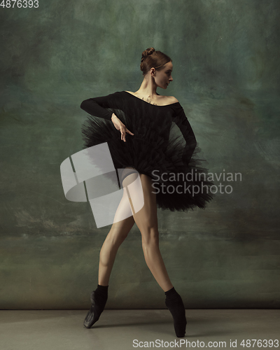 Image of Young graceful tender ballerina on dark studio background