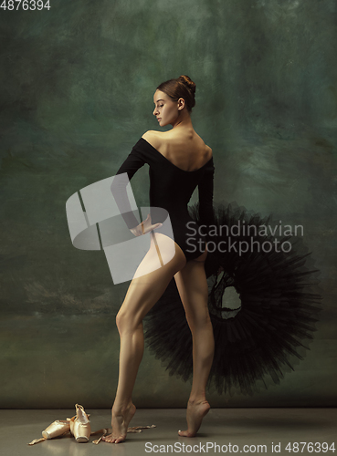 Image of Young graceful tender ballerina on dark studio background