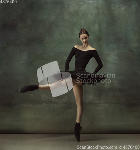 Image of Young graceful tender ballerina on dark studio background