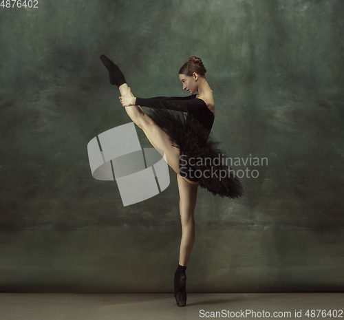 Image of Young graceful tender ballerina on dark studio background