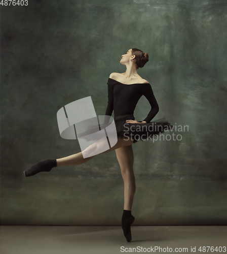 Image of Young graceful tender ballerina on dark studio background