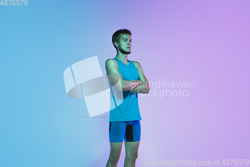 Image of Full length portrait of active young caucasian running, jogging man on gradient studio background in neon light