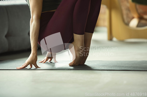 Image of Sporty young woman practicing yoga at home