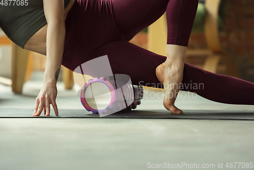 Image of Sporty young woman practicing yoga at home