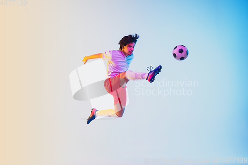 Image of Football or soccer player on gradient background in neon light - motion, action, activity concept