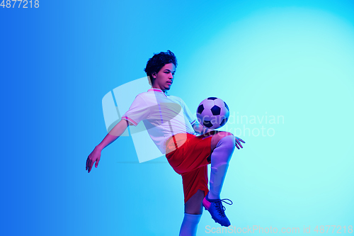 Image of Football or soccer player on gradient background in neon light - motion, action, activity concept