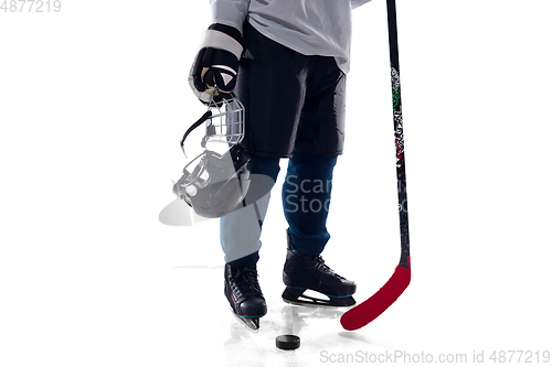 Image of Unrecognizable male hockey player with the stick on ice court and white background