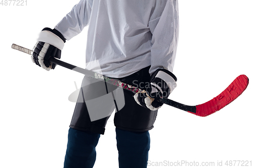 Image of Unrecognizable male hockey player with the stick on ice court and white background