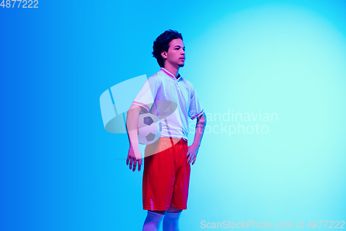 Image of Football or soccer player on gradient background in neon light - motion, action, activity concept